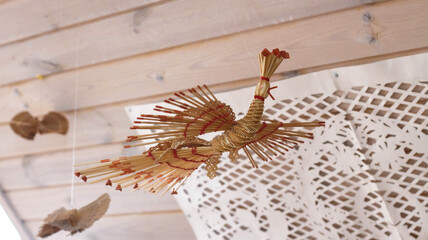 a bird made of straw suspended on a thread. Handmade, traditional.
