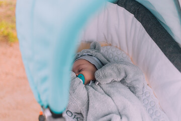 the baby sleeps in a stroller lifestyle . children's sleep on the street. a walk with a baby...