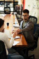 Businessman gives businesswoman dismissal contract to sign.