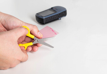 A man cuts off the required size of a protective film with scissors for gluing it to the screen of a navigator. Protect your screen from scratches and damage. Copy space for text