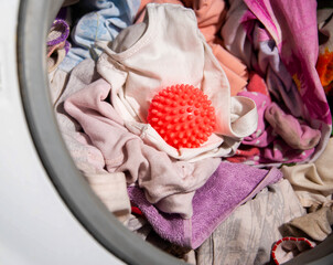 Red ball for washing clothes in the washing machine. Improving the quality of washing, close-up