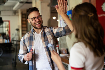 Cheerful coworkers giving high five. Businessman and businesswoman in office