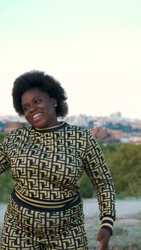 Portrait of a young Equatoguinean woman dancing happily at street.