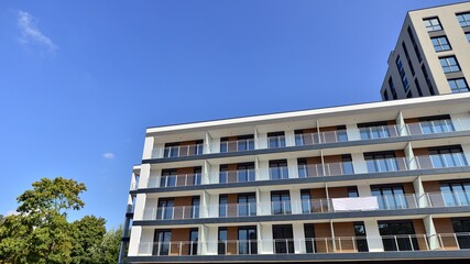 Obraz premium Modern luxury residential flat. Modern apartment building on a sunny day. Apartment building with a blue sky. Facade of a modern apartment building.