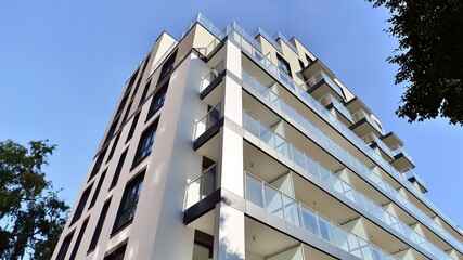 Modern residential building with new apartments in a green residential area. Eco architecture. Green tree and new apartment building. The harmony of nature and modernity.