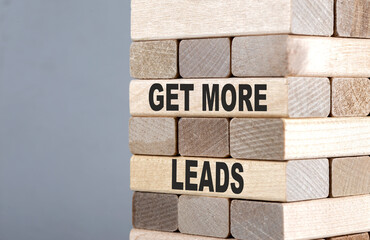 The text on the wooden blocks GET MORE LEADS
