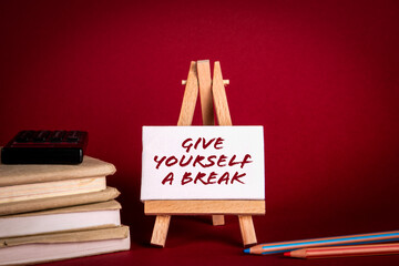 Give yourself a break. Miniature easel with text on a red background