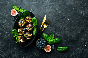 baked figs with goat cheese, walnuts and honey on a concrete background. Space for text. Top view.