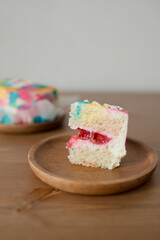 A small piece of cake on a wooden plate