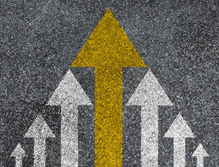 Yellow big arrow move leading from small white arrow on road asphalt for leadership concept.