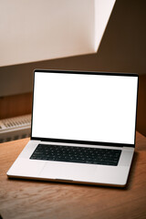 Concept of working remotely and  using laptop indoors. Laptop mockup on a wooden table, blank...