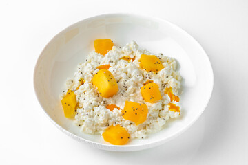 Breakfast of cottage cheese with peach and mango.Balanced, nutritious, tasty and nutritious food. Ready-made menu for a restaurant or for delivery. Isolated on a white background