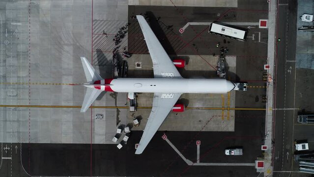 People and baggage boarding a plane at a airport terminal - cenital, Aerial view