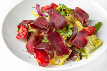 Dried dry age meat with vegetables. Balanced, nutritious, tasty and nutritious food. Ready-made menu for a restaurant or for delivery. Dish in a white plate isolated on a white background.