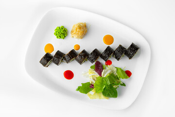 Rolls with fish paste and chuka. Balanced, nutritious, tasty and nutritious food. Ready-made menu for a restaurant or for delivery. Dish in a white plate isolated on a white background.