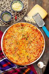 Pizza with cheese on a wooden table.