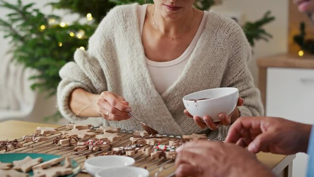 Multi ethnicity couple decorating sweet cookies at home during the Christmas. Shot with RED helium camera in 8K. 