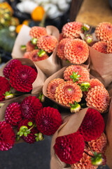 Corner with flowers on the street. Autumn flowers. Autumn decor. Autumn decor fair. Red and orange dahlias.