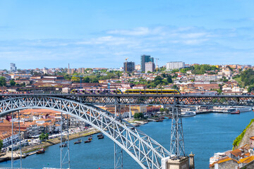 Part of the Dom Luis I bridge in Porto, with the tram passing over the bridge, on a sunny day.