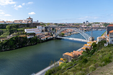 Fototapeta na wymiar Metallic bridge of Don Luis I in Porto, with a part scaffolded for works, on a sunny day.