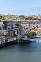 Fototapeta na wymiar Part of the Dom Luis I bridge in Porto, with people walking on the bridge, on a sunny day.