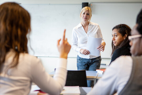 Teenage Students: Raising a Point. A pupil asking a question for her form tutor in class. From a series of related images.