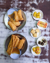Top view of Chinese doughnut or bread stick deep fried with sweet dumpling sauce and variety of steamed dim-sum in a mini plates on a serving table