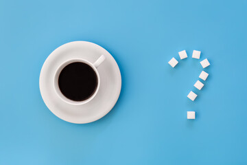 Cup of coffee and question mark made of sugar, flat lay.