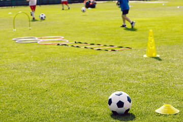 Obraz premium Close up of soccer ball and soccer training equipment. Football practice session for school kids. Soccer summer training camp for kids