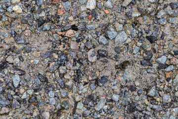 Wet ground section covered with gray granite rubble and sand