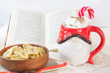 New Year's Eve background, Santa Claus mug with marshmallows, Christmas cookies, open book