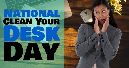Composite of national clean your desk day text and amazed biracial businesswoman