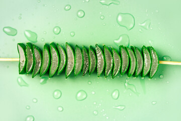 Aloe vera plant cuts on a green backdrop, top view. Aloe is widely used in herbal medicine and cosmetics industry.