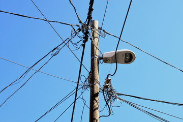 power distribution electrical cables on wood post. clear blue sky. overhead electrical wires and...
