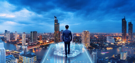 Professional business man on future city at night in Bangkok Thailand - 533630815