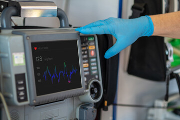Paramedic monitoring the patient heart rate with the medical equipment