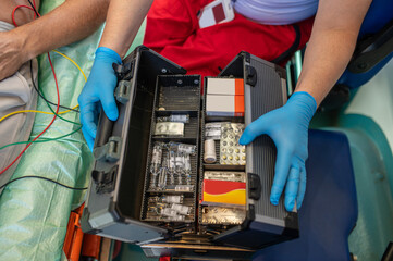 Paramedic choosing a medicine for administering to a sick person