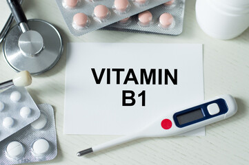 Stethoscope, pills and notebook with Vitamin b1 word on medical desk.