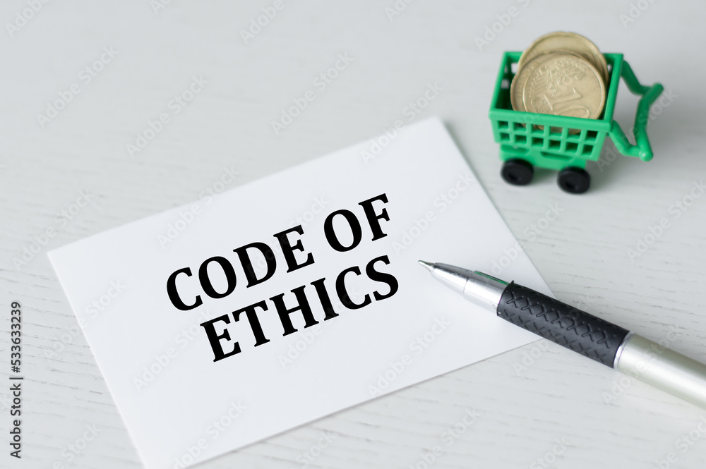 Poster code of ethics text on a card on a table next to a pen and coins