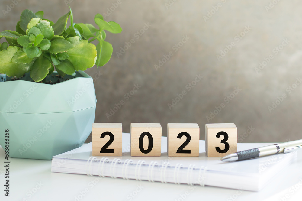 Poster on the table is a notebook with cubes with the text 2023, new year