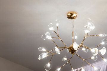 stylish beautiful new gold color chandelier on white ceiling