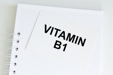 the text Vitamin b1 on a white card with a notebook on the table