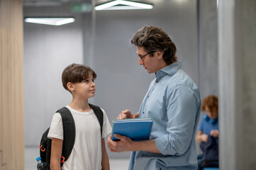 Obraz premium Teacher explaining something to a schoolboy at the recess