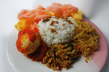 Nasi Uduk is a typical Jakarta Betawi dish, containing rice in coconut milk, vermicelli, eggs, kerupuk, tempe orek, and sambal