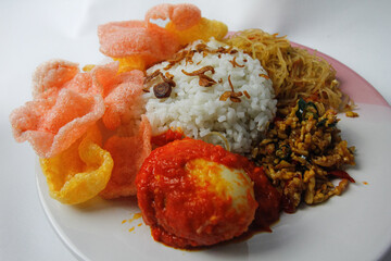 Nasi Uduk is a typical Jakarta Betawi dish, containing rice in coconut milk, vermicelli, eggs, kerupuk, tempe orek, and sambal