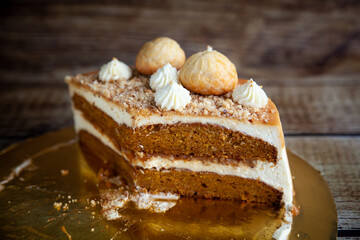 Homemade Carrot Cake with salted caramel decorated with meringues, ground nuts and cream