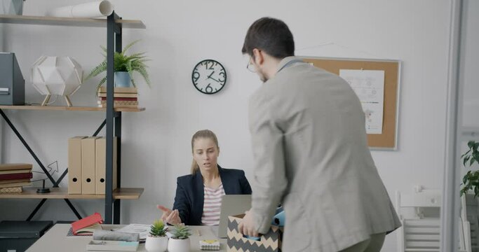 Unhappy man is leaving office with box of belongings being fired while colleagues are expressing happiness and joy over resignation. People and job concept.