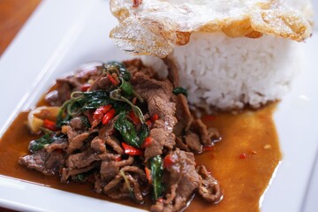 Stir fried beef with basil with fried egg on white plate  It's a simple a la carte.  that Thai people are very popular.