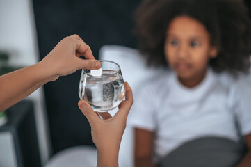 Cute girl talking a soluble pill while being sick