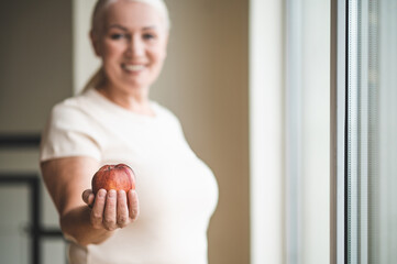 Joyful woman showing her favorite healthy fruit before the camera